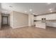Open-concept living area flows seamlessly into the kitchen, featuring stylish wood-look tile flooring at 5656 N 205Th Ln, Buckeye, AZ 85396