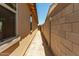 Narrow side yard showcasing privacy wall and potential for landscaping, leading to back of property at 5656 N 205Th Ln, Buckeye, AZ 85396
