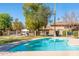 Community swimming pool with clear blue water, plenty of lounge seating, shade trees, and attractive landscaping at 1136 N 84Th Pl, Scottsdale, AZ 85257