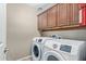 Laundry room with upper cabinets and Samsung washer/dryer at 23559 W Wayland Dr, Buckeye, AZ 85326