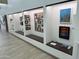 Hallway with artwork displayed on the walls and display shelves with recessed lighting at 25609 N Forest Rd # 13, Rio Verde, AZ 85263