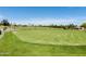 Well-maintained putting green on the golf course with blue skies and desert landscaping in the background at 25609 N Forest Rd # 13, Rio Verde, AZ 85263