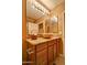 Bathroom vanity with wood cabinets, granite countertop, vessel sink, and decorative lighting at 11000 N 77Th Pl # 1083, Scottsdale, AZ 85260