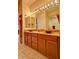 Bathroom vanity with wood cabinets, granite countertop, vessel sinks, and decorative lighting at 11000 N 77Th Pl # 1083, Scottsdale, AZ 85260