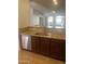 Modern kitchen with stainless steel dishwasher, granite countertops, and wood cabinets at 11000 N 77Th Pl # 1083, Scottsdale, AZ 85260