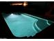 Night shot of in-ground pool with underwater lighting, built-in steps, and shimmering turquoise water at 12742 W Ash St, El Mirage, AZ 85335