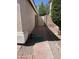 Side yard featuring a brick pathway leading to a gated entrance and a well-maintained wall at 12742 W Ash St, El Mirage, AZ 85335