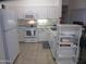Bright kitchen featuring white appliances, ample cabinetry, and tile flooring at 1881 E Kerby Farms Rd, Chandler, AZ 85249