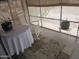 A cozy screened-in patio features a rocking chair, table with white cloth, and plant stand at 1881 E Kerby Farms Rd, Chandler, AZ 85249