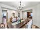 Formal dining room with a large wood table, chandelier, and neutral decor at 21800 N 260Th Ln, Buckeye, AZ 85396