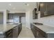 Modern kitchen with dark cabinetry, granite counters, and stainless steel appliances at 18949 W Ocotillo Rd, Waddell, AZ 85355