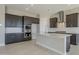 Modern kitchen with island, granite counters, and stainless steel appliances at 18949 W Ocotillo Rd, Waddell, AZ 85355