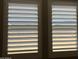 Interior view of two bright windows featuring adjustable, white louvered shutters for light and privacy control at 16068 W Questa Dr, Surprise, AZ 85387