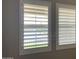 Bright interior view of two windows featuring adjustable, white louvered shutters for light and privacy control at 16068 W Questa Dr, Surprise, AZ 85387