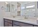 Bathroom vanity featuring double sinks, light countertops, and a large mirror with modern fixtures at 24620 W Hopi W St, Buckeye, AZ 85326