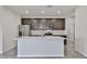 Modern kitchen featuring stainless steel appliances, a center island with a sink, and stylish dark wood cabinetry at 24620 W Hopi W St, Buckeye, AZ 85326