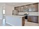 Modern kitchen featuring stainless steel appliances, a center island with a sink, and stylish dark wood cabinetry at 24620 W Hopi W St, Buckeye, AZ 85326