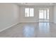 Spacious living room featuring tile floors, a window, and sliding glass doors at 24620 W Hopi W St, Buckeye, AZ 85326