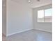 Bright, open-concept living room featuring sleek tile floors, recessed lighting, and abundant natural light from the window at 24620 W Hopi W St, Buckeye, AZ 85326