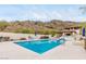 Community pool offers blue tiled water and surrounding lounge furniture and desert mountain views at 3800 E Lincoln Dr # 23, Phoenix, AZ 85018