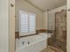 Relaxing bathroom with soaking tub, glass shower, and updated fixtures at 9478 E Corrine Dr, Scottsdale, AZ 85260