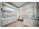 Bright bathroom featuring a soaking tub, glass shower, double vanity, and travertine tile at 730 E Mesquite St, Phoenix, AZ 85086