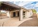 View of the backyard patio featuring pergola with outdoor lighting, tan stucco exterior, and brick flooring at 14859 W Surrey Dr, Surprise, AZ 85379