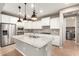 Well-lit kitchen features white cabinetry, granite countertops, and stainless steel appliances at 14859 W Surrey Dr, Surprise, AZ 85379