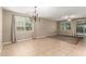 Spacious living room features neutral walls, tile and carpet flooring, and a modern chandelier at 14859 W Surrey Dr, Surprise, AZ 85379