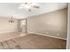 Open living room features neutral walls, carpet, tile flooring, and a modern chandelier at 14859 W Surrey Dr, Surprise, AZ 85379