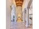 Arched hallway with stone pillars leading to a living area with a fireplace at 6240 N 59Th Pl, Paradise Valley, AZ 85253