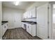 Bright laundry room with white cabinets and a built-in workspace at 2696 N 162Nd Ln, Goodyear, AZ 85395