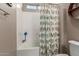 Bathroom with a tub-shower combo, a white shower head, and a colorful bird shower curtain at 13524 W Sierra Vista Dr, Glendale, AZ 85307