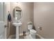 Bathroom with pedestal sink, round mirror, toilet and toilet paper, and towel hook at 13524 W Sierra Vista Dr, Glendale, AZ 85307