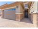 Close up of a garage and front door with decorative brick and an attractive paver walkway at 13524 W Sierra Vista Dr, Glendale, AZ 85307