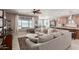 Open living room with a large sectional sofa, ceiling fan, and tile flooring at 13524 W Sierra Vista Dr, Glendale, AZ 85307