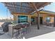 Covered outdoor kitchen and bar area with grill, seating, and pool view at 13524 W Sierra Vista Dr, Glendale, AZ 85307