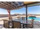 Covered patio dining area with pool view and orange curtains for shade at 13524 W Sierra Vista Dr, Glendale, AZ 85307