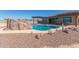 Backyard swimming pool featuring a rock waterfall, mature desert landscaping, and covered patio at 13524 W Sierra Vista Dr, Glendale, AZ 85307
