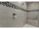 Tiled walk-in shower featuring a bench, handheld shower and accent mosaic tiling at 13524 W Sierra Vista Dr, Glendale, AZ 85307
