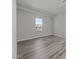 Well-lit bedroom featuring wood-look flooring and a window at 2233 W Hide Trl, Phoenix, AZ 85085