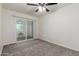 Bedroom with sliding glass doors to patio, ceiling fan, and neutral carpet, offering a serene space at 2608 W Berridge Ln # 220, Phoenix, AZ 85017