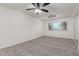 Bright, carpeted living room featuring a ceiling fan and a large window at 2608 W Berridge Ln # 220, Phoenix, AZ 85017