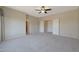 Spacious carpeted bedroom featuring a ceiling fan and a closet, providing ample storage at 27174 N 85Th Dr, Peoria, AZ 85383