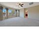 Bedroom featuring a ceiling fan, carpeting, and large window with curtains, offering natural light at 27174 N 85Th Dr, Peoria, AZ 85383