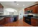 Well-lit kitchen with granite countertops, wooden cabinets, and stainless steel appliances, flowing into adjacent living area at 27174 N 85Th Dr, Peoria, AZ 85383