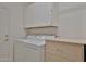 Bright laundry room with white washer, dryer, storage cabinets and shelves at 27174 N 85Th Dr, Peoria, AZ 85383