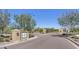 Community entrance featuring decorative pillars, gated access, and desert landscaping at 3576 N Carlton St, Buckeye, AZ 85396
