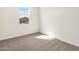 Bright bedroom featuring neutral carpet, a window and fresh white walls at 16038 W Desert Hollow Dr, Surprise, AZ 85387