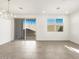 Dining area with modern chandelier, tile flooring, and access to backyard through sliding glass door at 16038 W Desert Hollow Dr, Surprise, AZ 85387